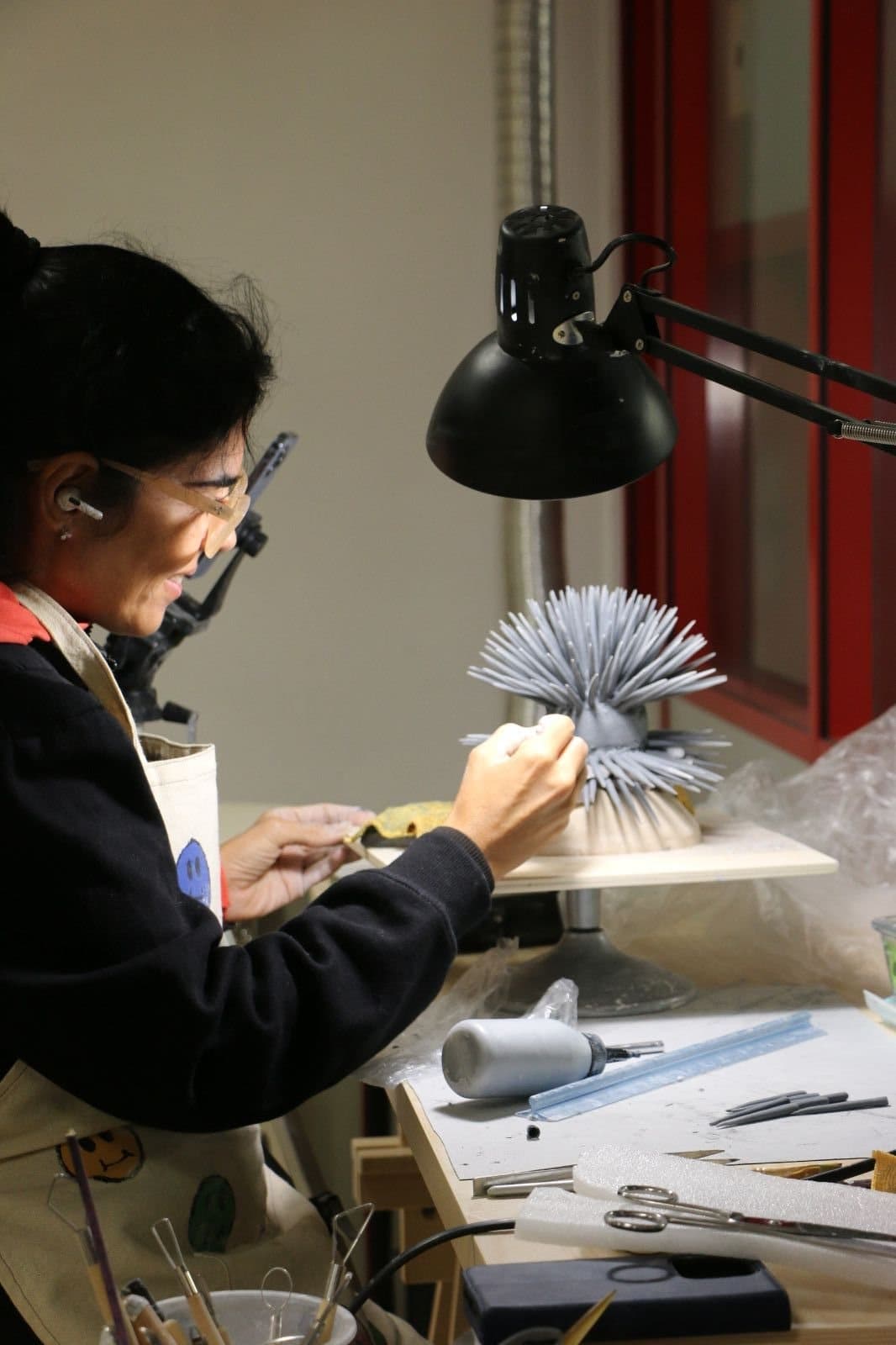 Renata dando forma a las púas de un erizo de mar de porcelana