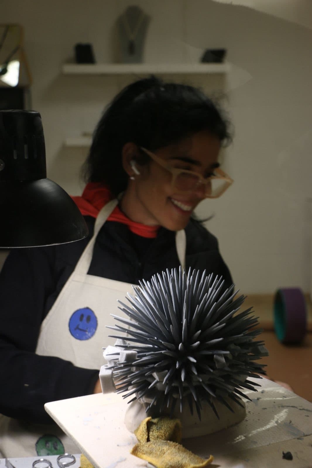 Renata en su mesa de trabajo, con un erizo de mar de porcelana